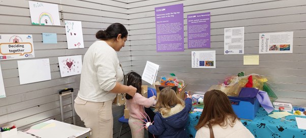 adults and children work to reflect democratic values through creative activities at FOSS2025